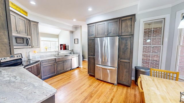 kitchen with dark brown cabinetry, appliances with stainless steel finishes, sink, and light stone counters