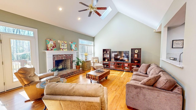 living room featuring high vaulted ceiling, plenty of natural light, hardwood / wood-style floors, and a fireplace