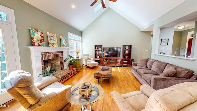 living room with vaulted ceiling, ceiling fan, a fireplace, and hardwood / wood-style floors