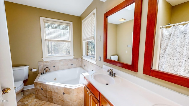 bathroom featuring vanity, toilet, and tiled bath