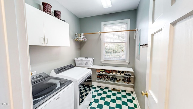 clothes washing area with separate washer and dryer and cabinets