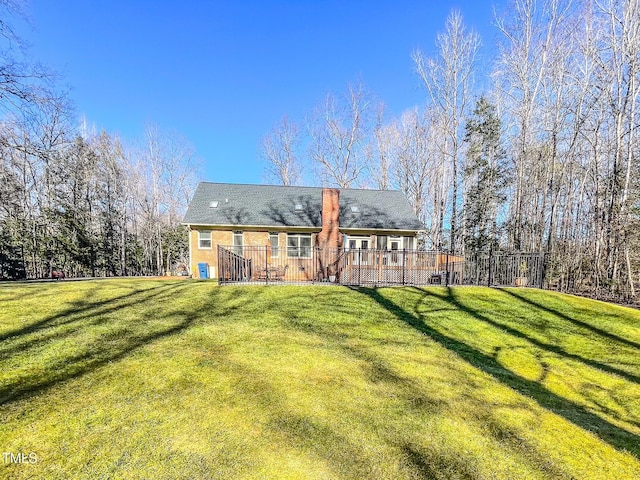 back of property featuring a wooden deck and a yard