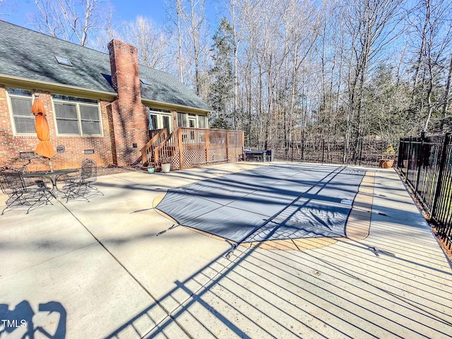 view of pool featuring a wooden deck and a patio area