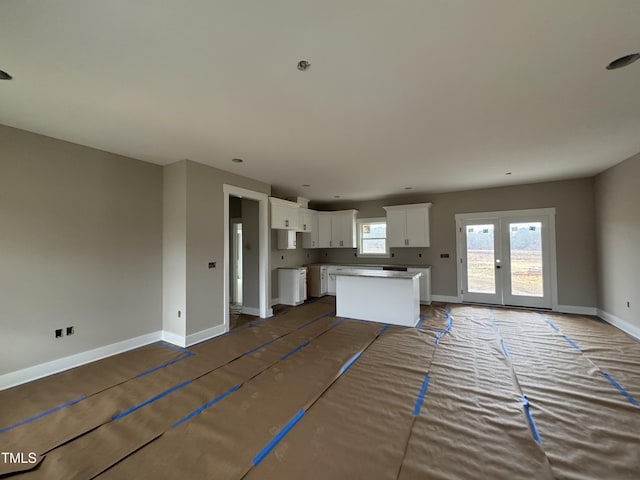 kitchen featuring french doors, a center island, and white cabinets