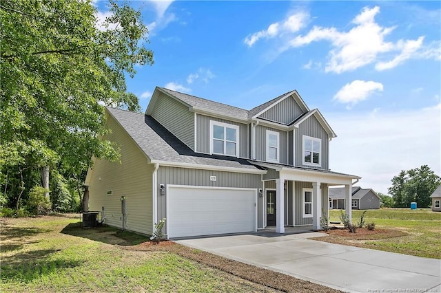 5210 Maxwell Rd, Stedman, NC 28391 - view of front facade with concrete driveway, a front lawn, central AC unit, and a porch