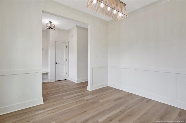 5210 Maxwell Rd, Stedman, NC 28391 - empty room with a chandelier, light wood-style flooring, wainscoting, and a decorative wall