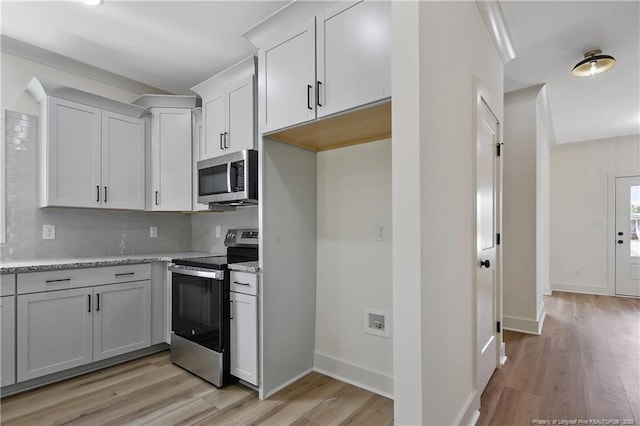 5210 Maxwell Rd, Stedman, NC 28391 - kitchen with appliances with stainless steel finishes, tasteful backsplash, light wood-style flooring, light stone countertops, and baseboards