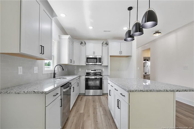 5210 Maxwell Rd, Stedman, NC 28391 - kitchen featuring appliances with stainless steel finishes, light wood-style floors, decorative backsplash, a sink, and recessed lighting