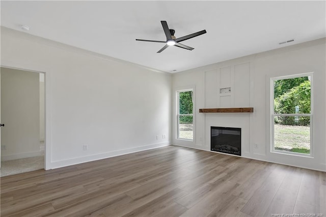 5210 Maxwell Rd, Stedman, NC 28391 - unfurnished living room featuring a ceiling fan, wood finished floors, a glass covered fireplace, and baseboards