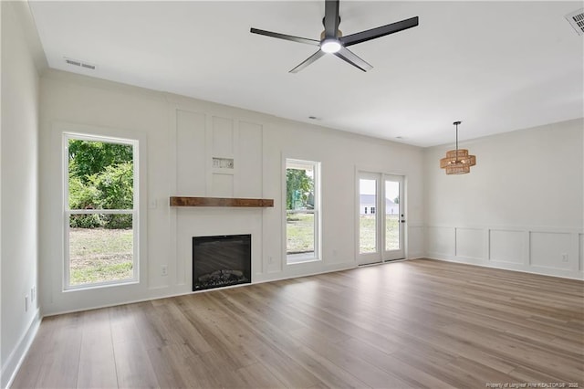 5210 Maxwell Rd, Stedman, NC 28391 - unfurnished living room with a decorative wall, plenty of natural light, a fireplace, light wood-style floors, and ceiling fan