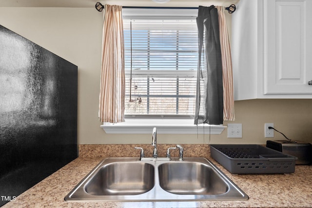 kitchen featuring white cabinetry and sink