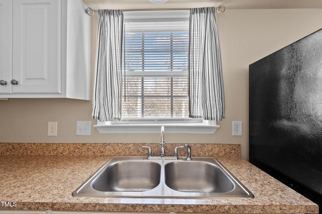 kitchen featuring white cabinetry and sink