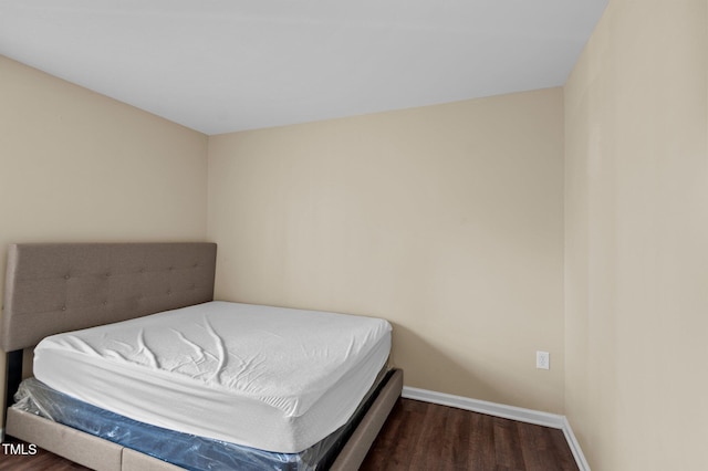 bedroom with dark hardwood / wood-style floors