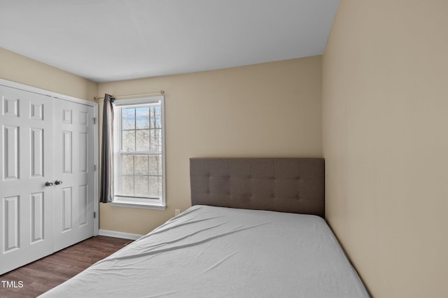 bedroom with dark hardwood / wood-style floors and a closet