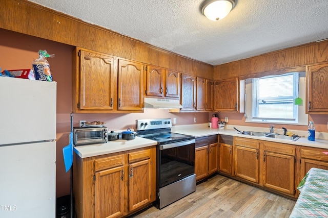 kitchen with sink, white fridge, a textured ceiling, stainless steel electric stove, and light wood-type flooring