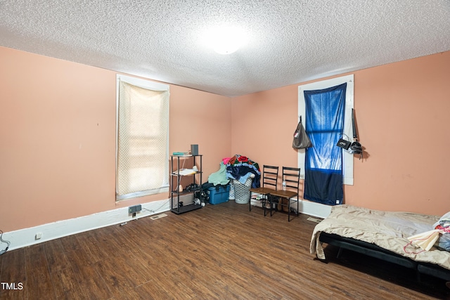 bedroom featuring hardwood / wood-style flooring and a textured ceiling