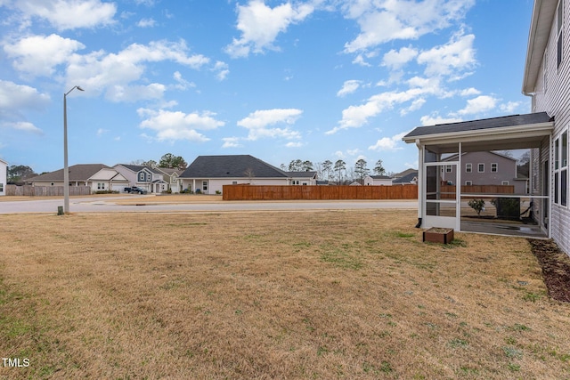 view of yard with a residential view and a sunroom