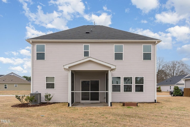 rear view of house featuring central air condition unit, a lawn, and a sunroom