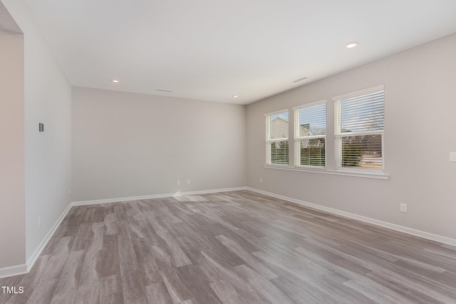 unfurnished room with recessed lighting, baseboards, and light wood-style floors