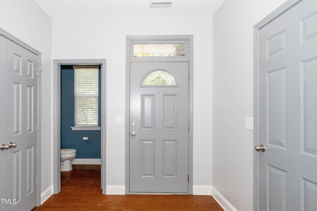 foyer entrance with dark wood-style floors and baseboards