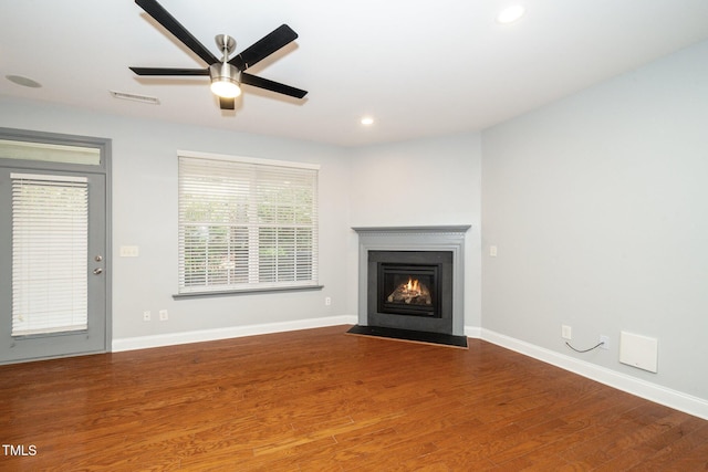 unfurnished living room with a fireplace with flush hearth, wood finished floors, recessed lighting, ceiling fan, and baseboards