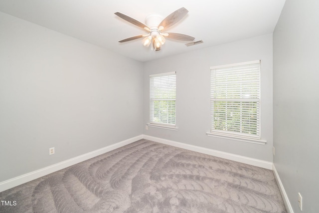 carpeted empty room with baseboards and a ceiling fan