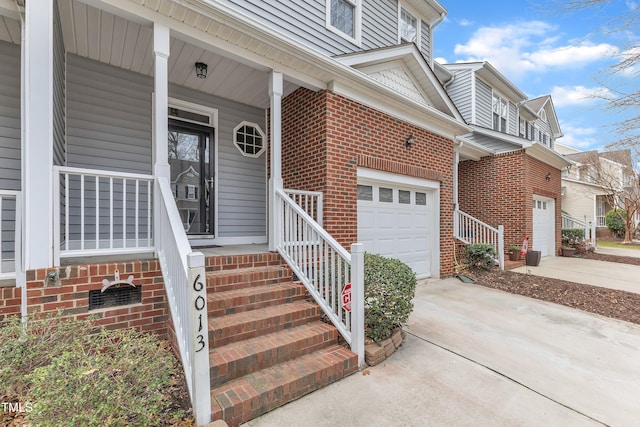 property entrance featuring brick siding, a porch, and driveway