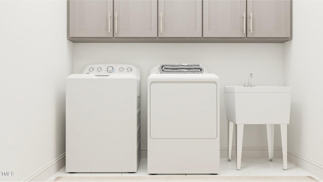 clothes washing area with washer and clothes dryer and cabinets