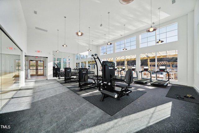 workout area with a towering ceiling and carpet floors