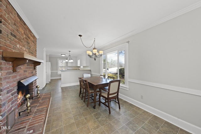 dining room with crown molding, a healthy amount of sunlight, a fireplace, and an inviting chandelier