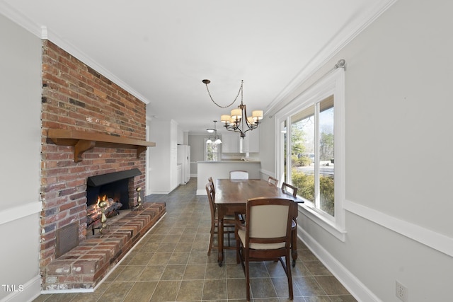 tiled dining area featuring crown molding, a brick fireplace, and a notable chandelier