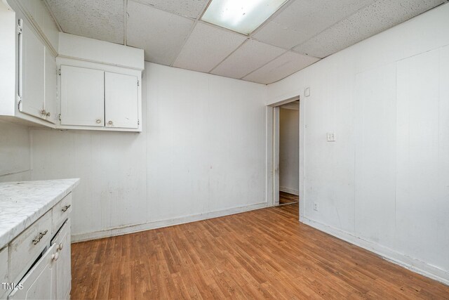 interior space featuring a paneled ceiling and light wood-type flooring