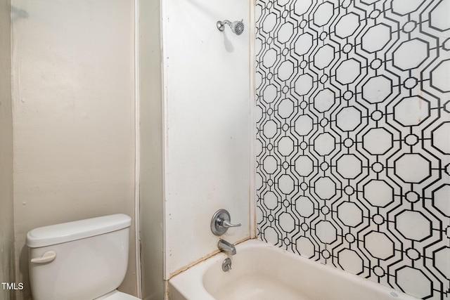 bathroom featuring tiled shower / bath and toilet