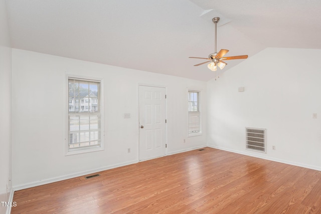 empty room with lofted ceiling, ceiling fan, and light hardwood / wood-style flooring