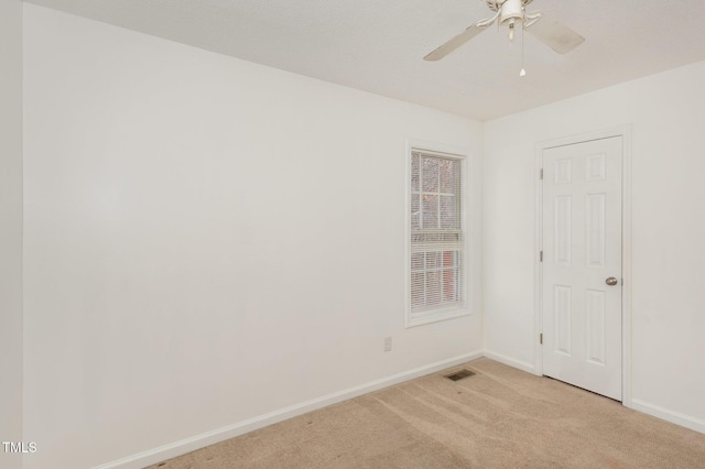 carpeted spare room with ceiling fan