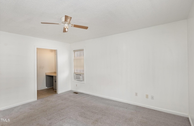 empty room featuring cooling unit, ceiling fan, light carpet, and a textured ceiling