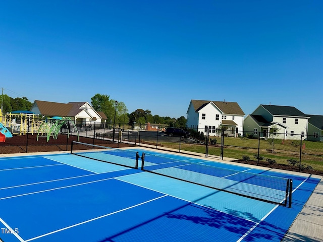 view of tennis court with a playground and basketball hoop