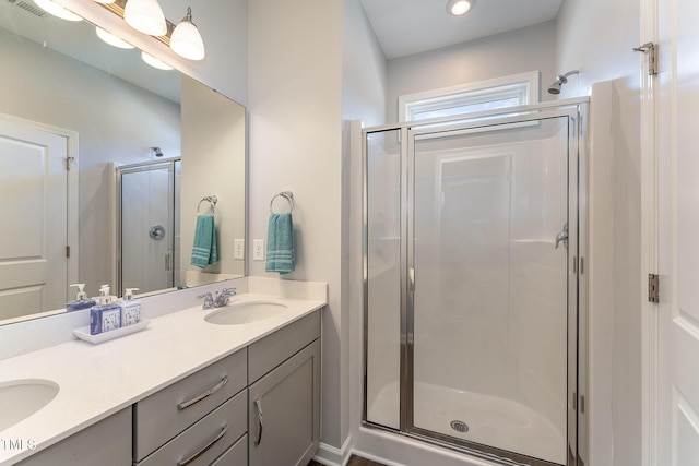 bathroom featuring a shower with door and vanity