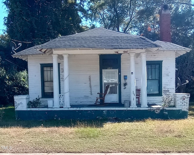 view of front of property with a porch and a front lawn