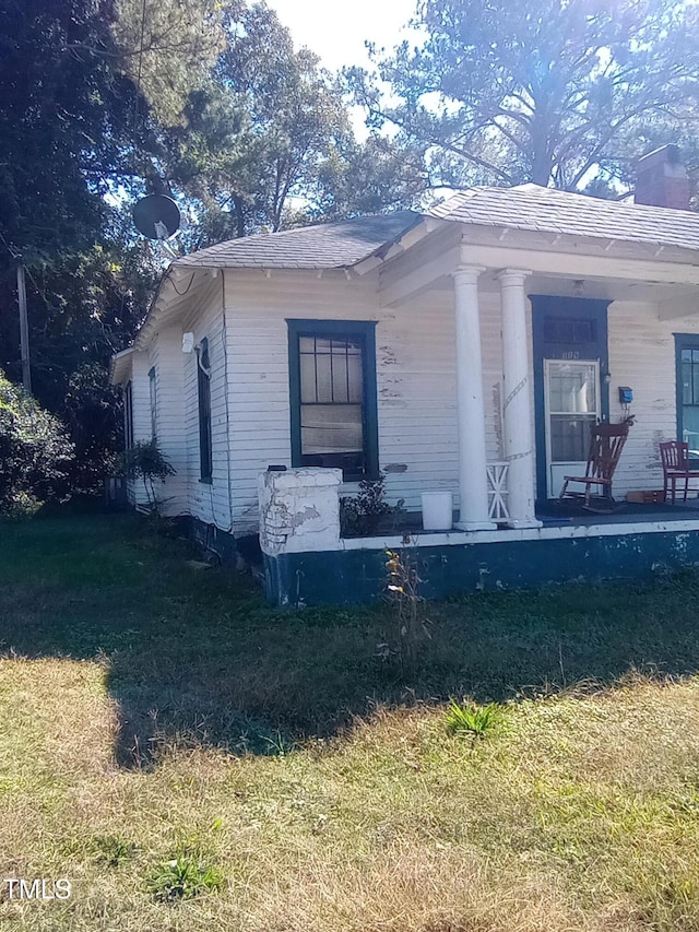 view of side of property with a lawn and a porch