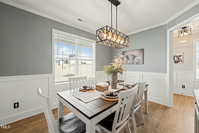 dining area featuring crown molding and light hardwood / wood-style flooring