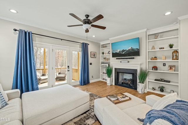 living room with crown molding, ceiling fan, and light hardwood / wood-style floors