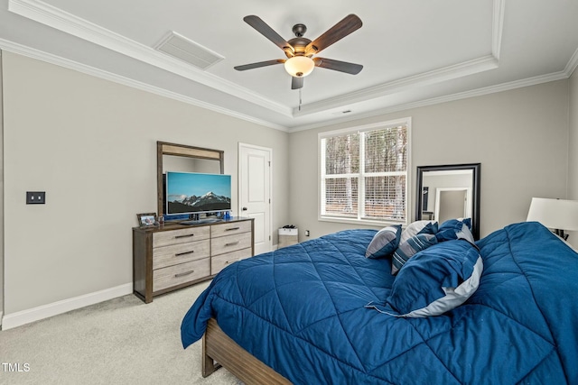 carpeted bedroom with crown molding, a tray ceiling, and ceiling fan