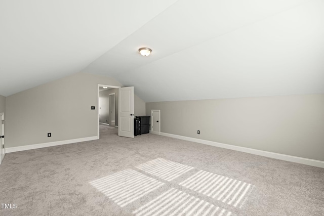 additional living space with lofted ceiling and light carpet