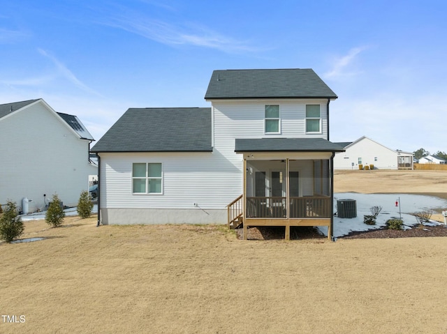 back of house featuring a sunroom, a yard, and central AC unit