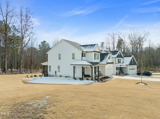 back of property featuring cooling unit, covered porch, and a lawn