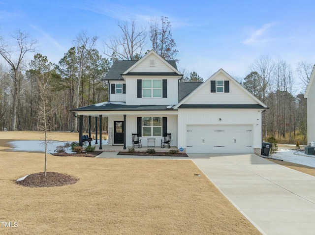 view of front facade featuring a garage, covered porch, and a front lawn