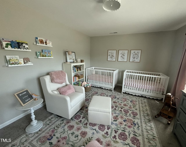 bedroom featuring a crib and carpet flooring