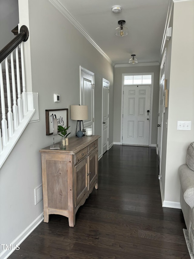 entrance foyer featuring ornamental molding and dark hardwood / wood-style floors