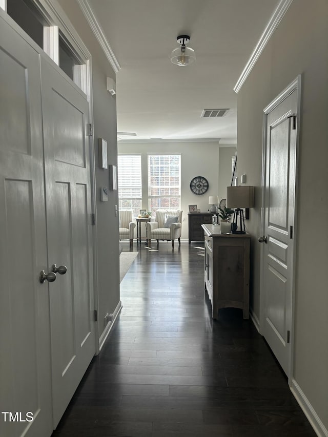 hall with ornamental molding and dark wood-type flooring